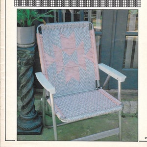 May include: A folding patio chair with a woven seat and backrest. The seat and back feature a pink and gray geometric pattern. The chair has a silver frame and white armrests. The text "DESERT SAND" is at the top of the image.