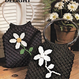 May include: Two black crocheted bags with white daisy flower designs. The bags have white rope handles. The text "DAISY DELIGHT" is printed on the top of the image.