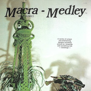 May include: A green macrame frog plant hanger with a spider plant and a green macrame frog pot with a plant. The image has the text "Macra - Medley" and "LEE ORIGINALS". The image also has the text "A variety of unique and entertaining designs including animal art, hangings and something new - standings - ".