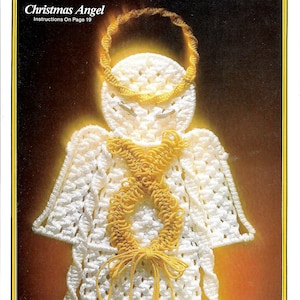 May include: White crocheted Christmas angel ornament with a gold halo and a gold bow. The angel is wearing a white dress with gold trim. Instructions for making the angel are on page 19.