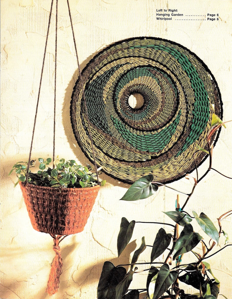 May include: A hanging macrame wall decor with a circular design in shades of green and brown. A brown macrame plant hanger with a green plant is hanging from the ceiling.
