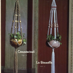 Peut inclure: Deux suspensions macram&eacute;es pour plantes, l'une avec un pot brun et l'autre avec un pot rose. La suspension brune a des perles en bois et un long pompon. La suspension rose a de petites figurines d'ours et un pompon blanc. Le texte "Commencant Page 11" est sous la suspension brune et "La Bonnette Page 11" est sous la suspension rose.