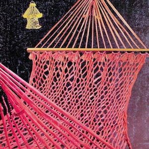 以下が含まれることがあります： 木製のフレームが付いたピンクのロープ製のハンモック。ハンモックは天井から吊り下げられています。