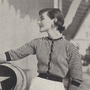 May include: A black and white striped cardigan with a button closure. The cardigan has a crew neckline and three-quarter sleeves.