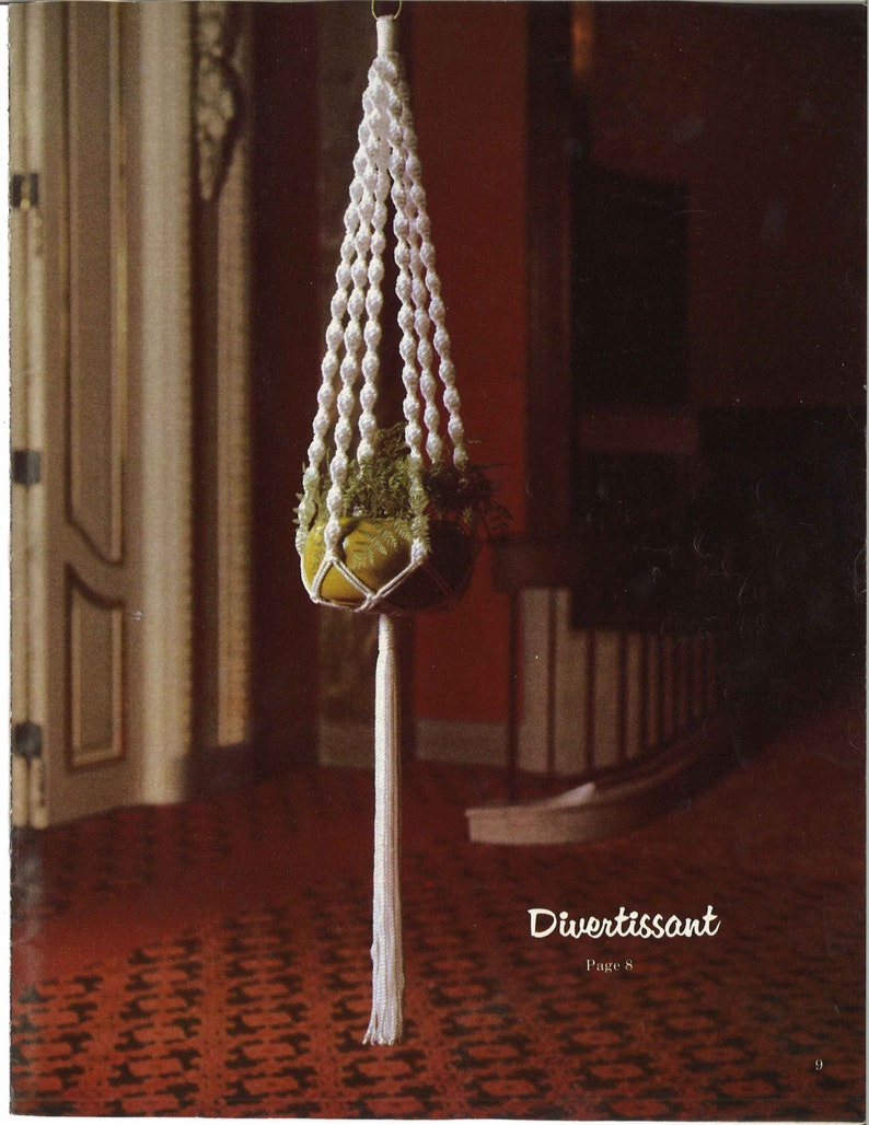 Peut inclure: Un porte-plante en macram&eacute; blanc avec une plante verte dans un pot jaune. Le porte-plante a un long pompon et est suspendu &agrave; un crochet de plafond. Le texte "Divertissant Page 8" est visible en bas de l'image.