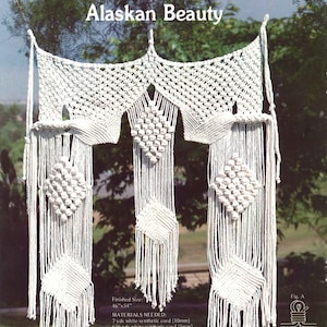 May include: White macrame wall hanging with a geometric design. The finished size is 46 inches by 54 inches. Materials needed include 7 yards of white synthetic cord (10mm) and 656 yards of white synthetic cord (5mm).