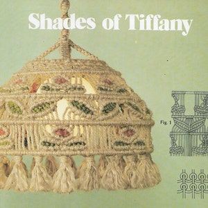 May include: A macrame lampshade with a floral design in shades of beige, green, and pink. The lampshade is made of natural fiber rope and has a fringe trim. The image also includes diagrams showing the knotting techniques used to create the lampshade.