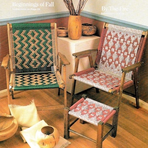 Peut inclure: Deux chaises en bois avec des sièges tissés en motifs vert et rouge, un tabouret en bois avec un siège tissé en motifs rose et blanc, et un vase en bois avec des branches séchées. Les chaises et le tabouret sont sur un sol en bois. Le texte "Beginnings of Fall" et "By The Fire" est visible sur l'image.