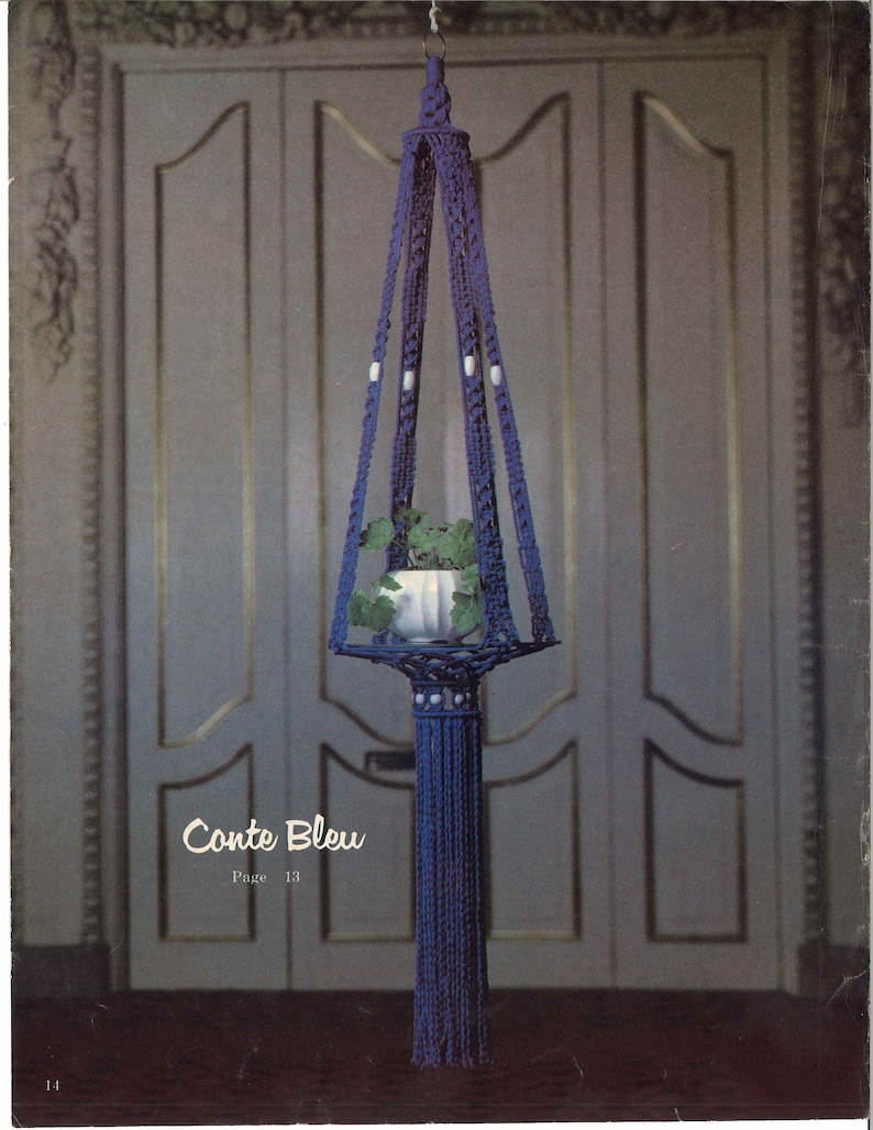 Peut inclure: Un porte-plante en macram&eacute; bleu avec un pot blanc et une plante &agrave; l'int&eacute;rieur. Le porte-plante est suspendu &agrave; un crochet sur une porte blanche. Le texte "Conte Bleu Page 13" est imprim&eacute; sous le porte-plante.