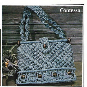 May include: A blue crocheted handbag with wooden beads and a woven strap. The bag is called "Contessa".