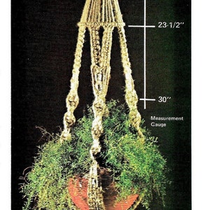 May include: A macrame plant hanger made of natural fiber rope with a hanging pot and a green plant. The hanger is 30 inches long.