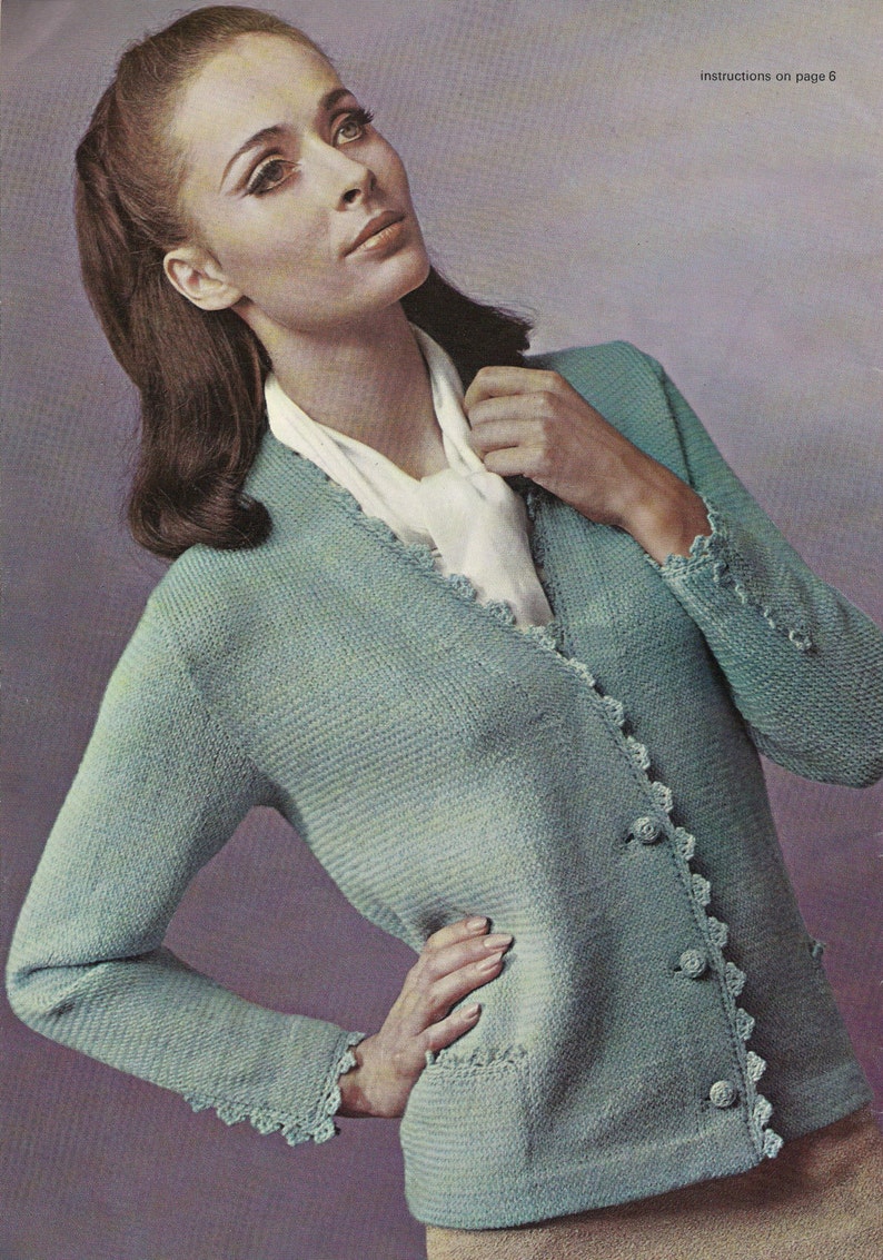 May include: A light blue cardigan with crocheted trim and buttons. The cardigan has a V-neck and long sleeves. Instructions on page 6.
