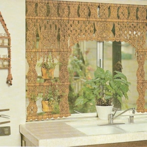 Op de afbeelding: Een keuken met een macramé wandhanger met planten in potten, een macramé kruidenrek en een macramé bestekhouder. De wandhanger is verdeeld in vier secties, gelabeld "Sectie 1", "Sectie 2", "Sectie 3" en "Sectie 4".