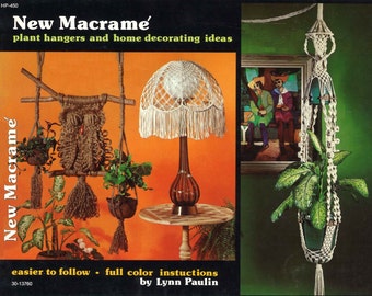 May include: A book cover with the title "New Macrame'" and a subtitle "plant hangers and home decorating ideas". The cover features three macrame plant hangers, one with an owl design, one with a lampshade, and one with a hanging plant.