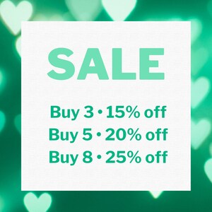 Puede incluir: Un cuadrado blanco con la palabra "SALE" en letras verde menta. Debajo, el texto dice "Buy 3 &bull; 15% off", "Buy 5 &bull; 20% off" y "Buy 8 &bull; 25% off". El fondo es un verde borroso con bokeh en forma de coraz&oacute;n.
