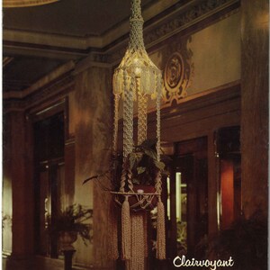 Peut inclure: Un porte-plante en macram&eacute; avec un design tiss&eacute; brun clair. Le porte-plante est suspendu au plafond et contient un pot avec une plante verte. Le texte "Clairvoyant Page 20" est visible en bas de l'image.