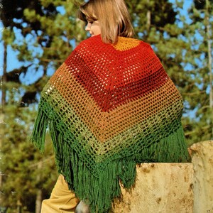 May include: A crocheted shawl with a rainbow color gradient, featuring a green fringe. The shawl is made with a simple crochet stitch and is a great way to add a touch of color to any outfit.