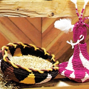 May include: Two woven baskets, one a round bowl filled with grain and the other a tall, cone-shaped basket with white and pink stripes. Both baskets are made with colorful yarn.