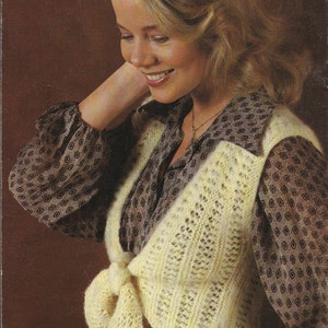 Puede incluir: Imagen de moda vintage con una mujer que lleva un chaleco de punto amarillo claro con cierre de lazo. El chaleco se superpone a una blusa estampada. El número 8 es visible en la esquina inferior izquierda.