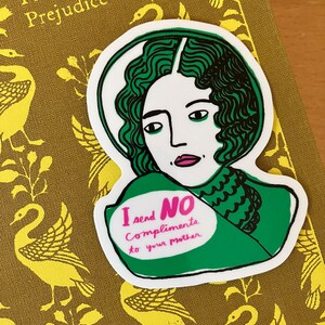 Puede incluir: Una pegatina con una ilustraci&oacute;n verde y blanca de una mujer con pelo verde. La pegatina tiene el texto "I send NO Compliments to your mother" en rosa y verde. La pegatina est&aacute; sobre un libro titulado "Pride and Prejudice".