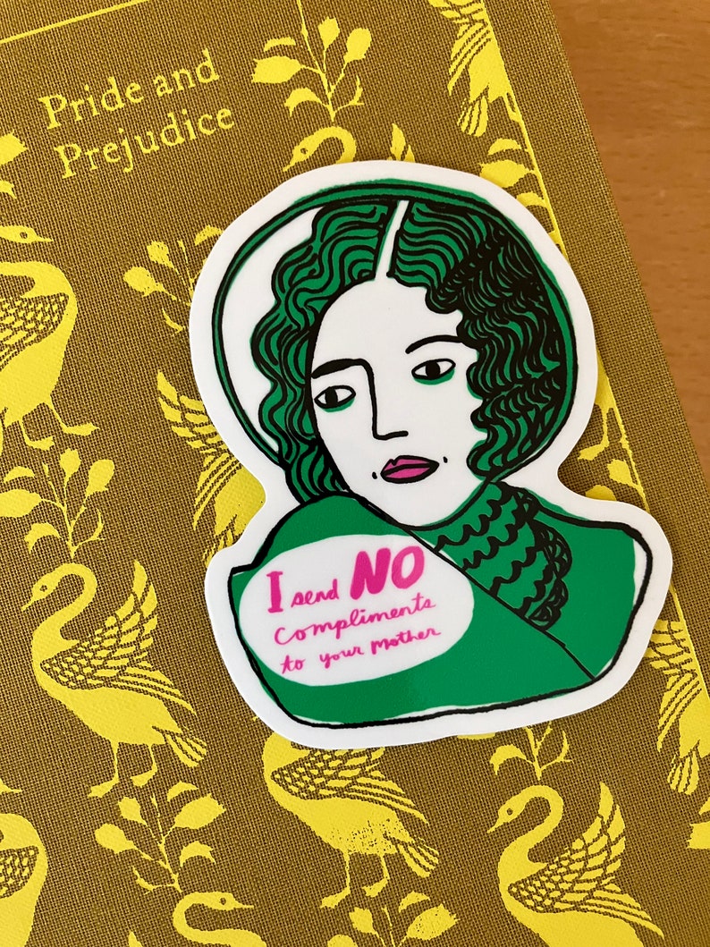 Puede incluir: Una pegatina con una ilustraci&oacute;n verde y blanca de una mujer con pelo verde. La pegatina tiene el texto "I send NO Compliments to your mother" en rosa y verde. La pegatina est&aacute; sobre un libro titulado "Pride and Prejudice".