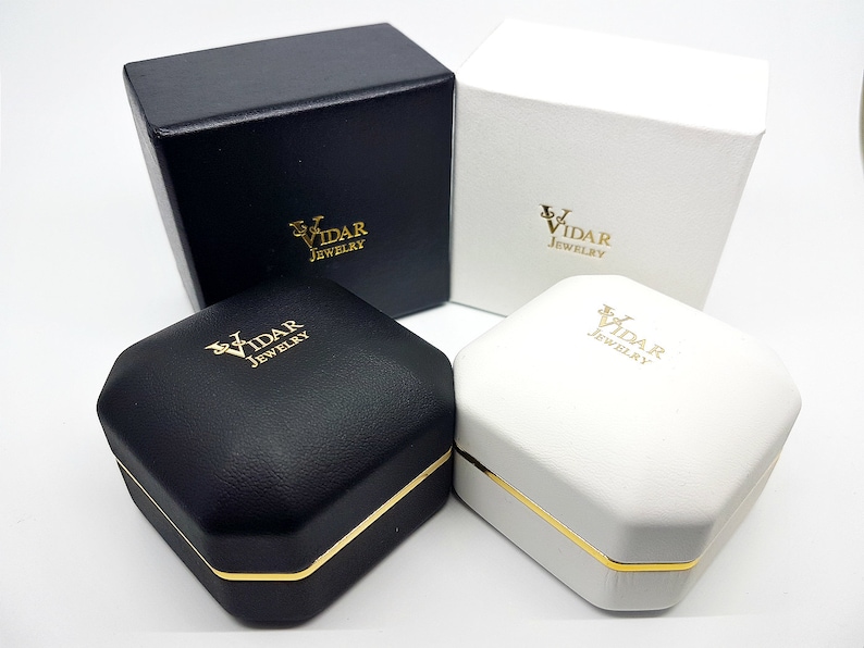 May include: Four jewelry boxes, two black and two white, are displayed. Each box has a gold-colored trim and the "LV VIDAR JEWELRY" logo in gold. The boxes are square and octagonal, with a textured appearance.