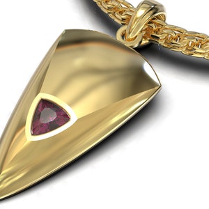 May include: A gold pendant in the shape of a spear point with a small, triangular, pink gemstone set in the center.