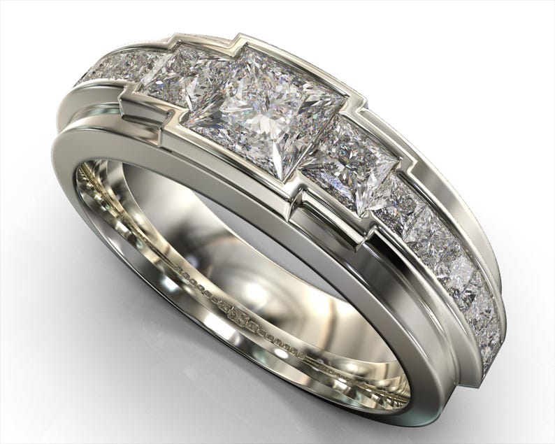 May include: A silver-toned ring featuring three large, square-cut diamonds set in a geometric design. The band is accented with smaller, pave-set diamonds, creating a luxurious and elegant appearance. This ring is a statement piece of jewelry.