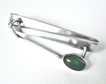 Exclusivo pasador de corbata modernista de plata de ley con piedra verde.