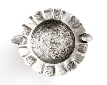 Cinzeiro Maciel 900 em prata com base e desenho de calendário asteca ou maia, fabricado no México.