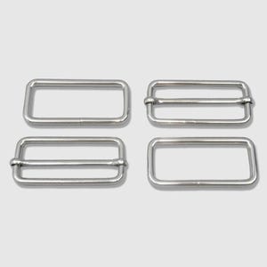 May include: Four silver-colored rectangular metal buckles. Two buckles have a single bar, and two have a double bar. These buckles are likely used for straps or belts, offering a secure and adjustable closure.