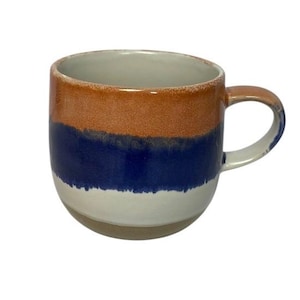 May include: A ceramic mug with a brown, blue, and white color scheme. The mug has a rounded base and a handle. The top portion is brown, the middle is blue, and the bottom is white. The mug is suitable for hot or cold beverages.