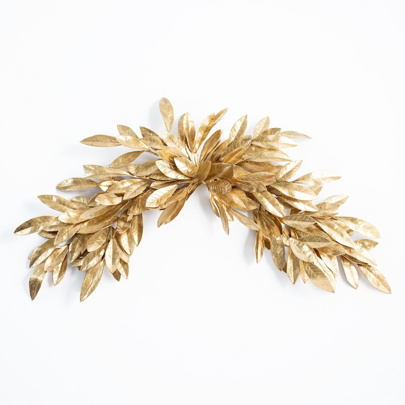 K&ouml;nnte beinhalten: Ein goldener Bl&auml;tterkranz, perfekt, um jedem Raum einen Hauch von Eleganz zu verleihen.