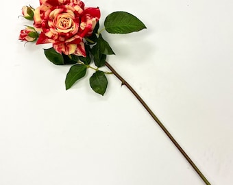 May include: A single artificial rose with a large, open bloom and several buds. The petals are a mix of red and cream, with green leaves and a brown stem. The rose is a realistic replica of a natural flower.