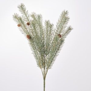May include: A decorative artificial pine branch featuring muted sage green needles and four small brown pinecones. The branch has a central stem that splits into multiple smaller sprigs, creating a full, fan-like arrangement of evergreen foliage.