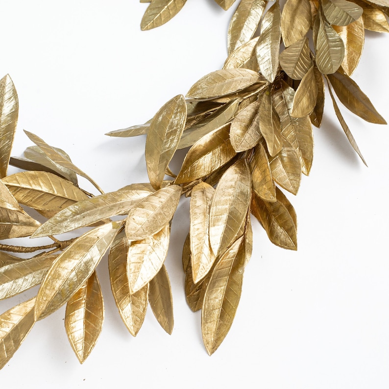 May include: A gold leaf garland with a realistic look. The garland is made of artificial leaves and is perfect for adding a touch of elegance to any space.