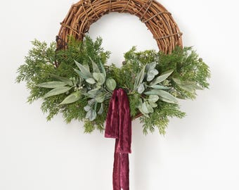 Recolección de frutos del bosque: Corona navideña para la puerta principal con piñas cubiertas de nieve, ramas de cedro y agujas de eucalipto.