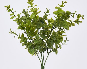 May include: A bundle of artificial eucalyptus stems with green leaves. The leaves have a textured appearance and are arranged on multiple branches. The stems are a darker green color, and the background is plain white.