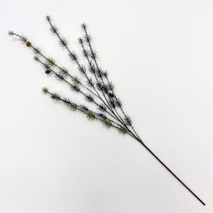 May include: A sprig of artificial pine with dark green needles and small brown pine cones.