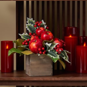 Klassische Weihnachtsarrangement aus rotem Apfel, Stechpalme & Magnolienblatt in einem kleinen Pflanzkasten aus Holz