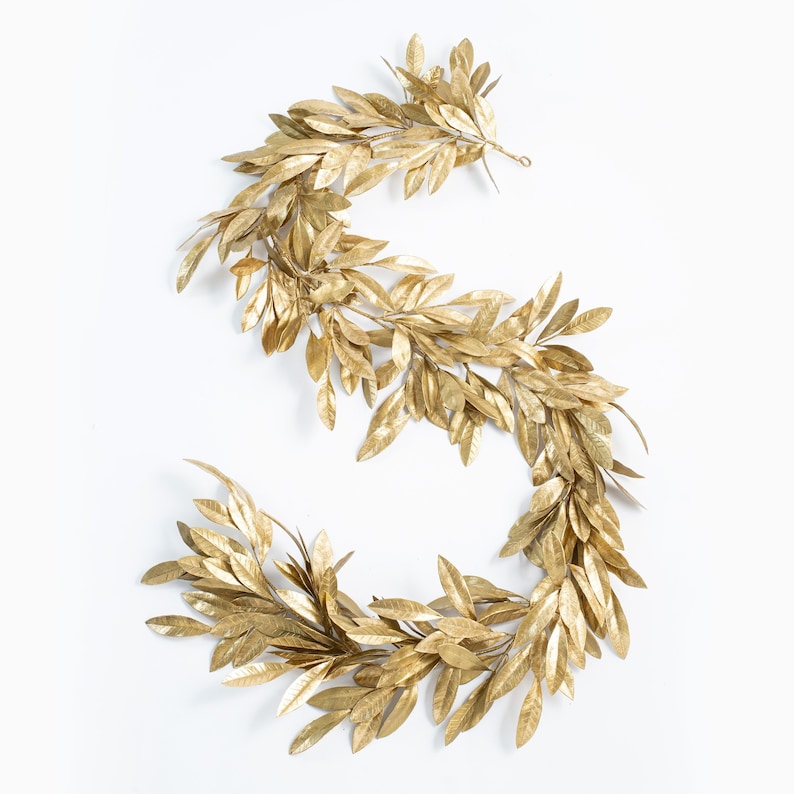 May include: A gold garland of artificial leaves, arranged in an S shape, perfect for adding a touch of elegance to your home decor.