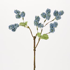 May include: A blue artificial flower sprig with multiple clusters of flowers and green leaves on a brown stem.
