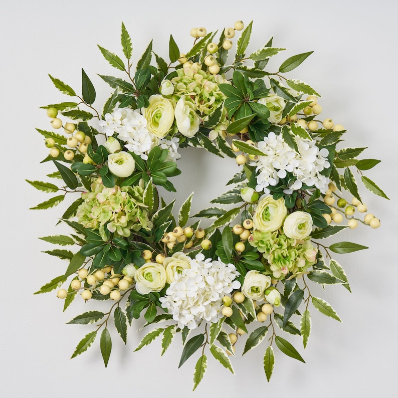 Peut inclure: Une couronne florale verte et blanche avec des hortensias blancs, des feuilles vertes et des fleurs blanches et jaunes.