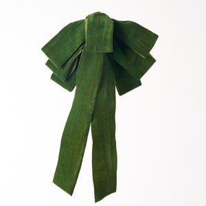 May include: A large green velvet bow with two long tails.