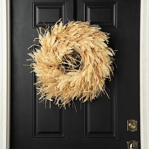 Voordeurkrans met gedroogde herfstgras raffia en herfstbessen