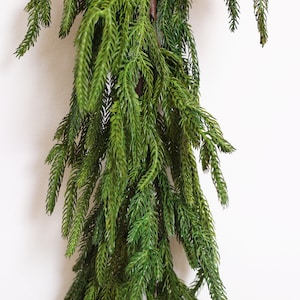May include: A long, green garland of artificial pine branches, perfect for adding a touch of greenery to your home decor.