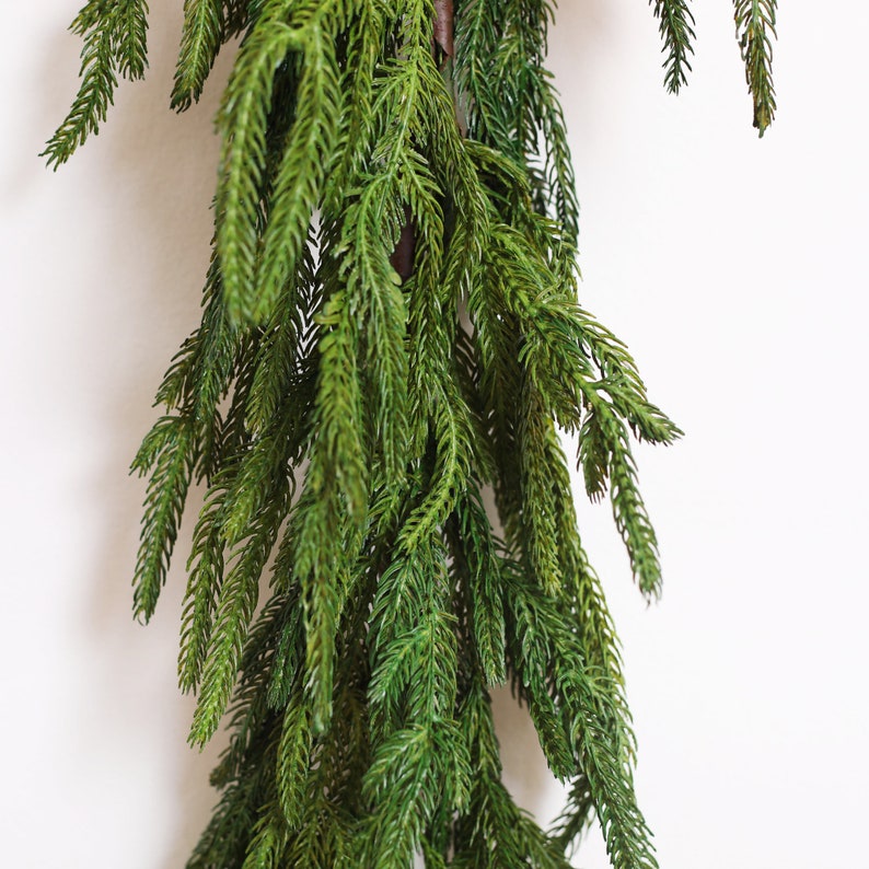 May include: A long, green garland of artificial pine branches, perfect for adding a touch of greenery to your home decor.