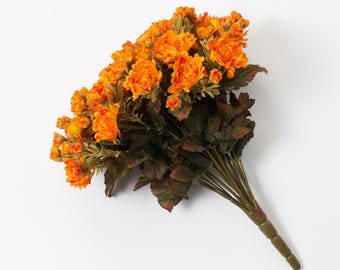 Könnte beinhalten: Ein Strauß künstlicher orangefarbener Blumen mit grünen Stielen und Blättern.