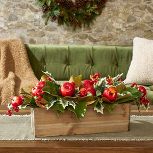 Klassische Weihnachtsarrangement aus rotem Apfel, Stechpalme & Magnolienblatt in einem großen Holzkasten