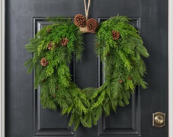 Corona navideña para puerta de entrada de invierno con toque natural de hojas perennes, vegetación mixta y piñas